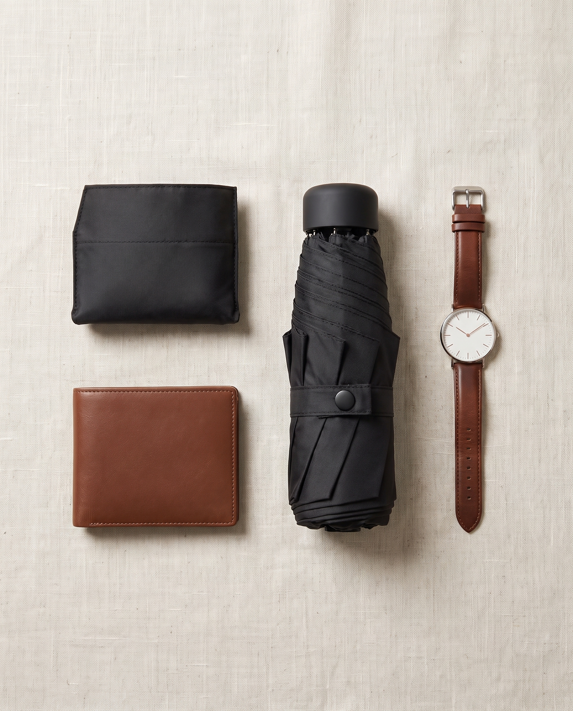 Montrave Compact Travel Umbrella flat lay with wallet and watch