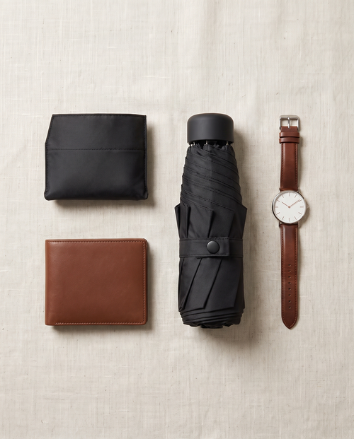 Montrave Compact Travel Umbrella flat lay with wallet and watch